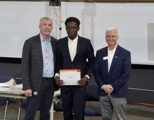 Software Engineering student, Elvis Kimara, receives his $2,000 third place award for his project, Gutter.