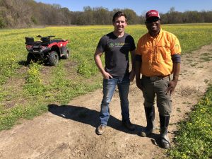 Photo of Hora and a farmer standing in a field