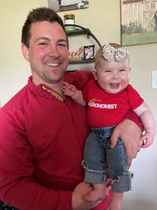 Photo of Hora and his 6 month old daughter wearing Iowa State great