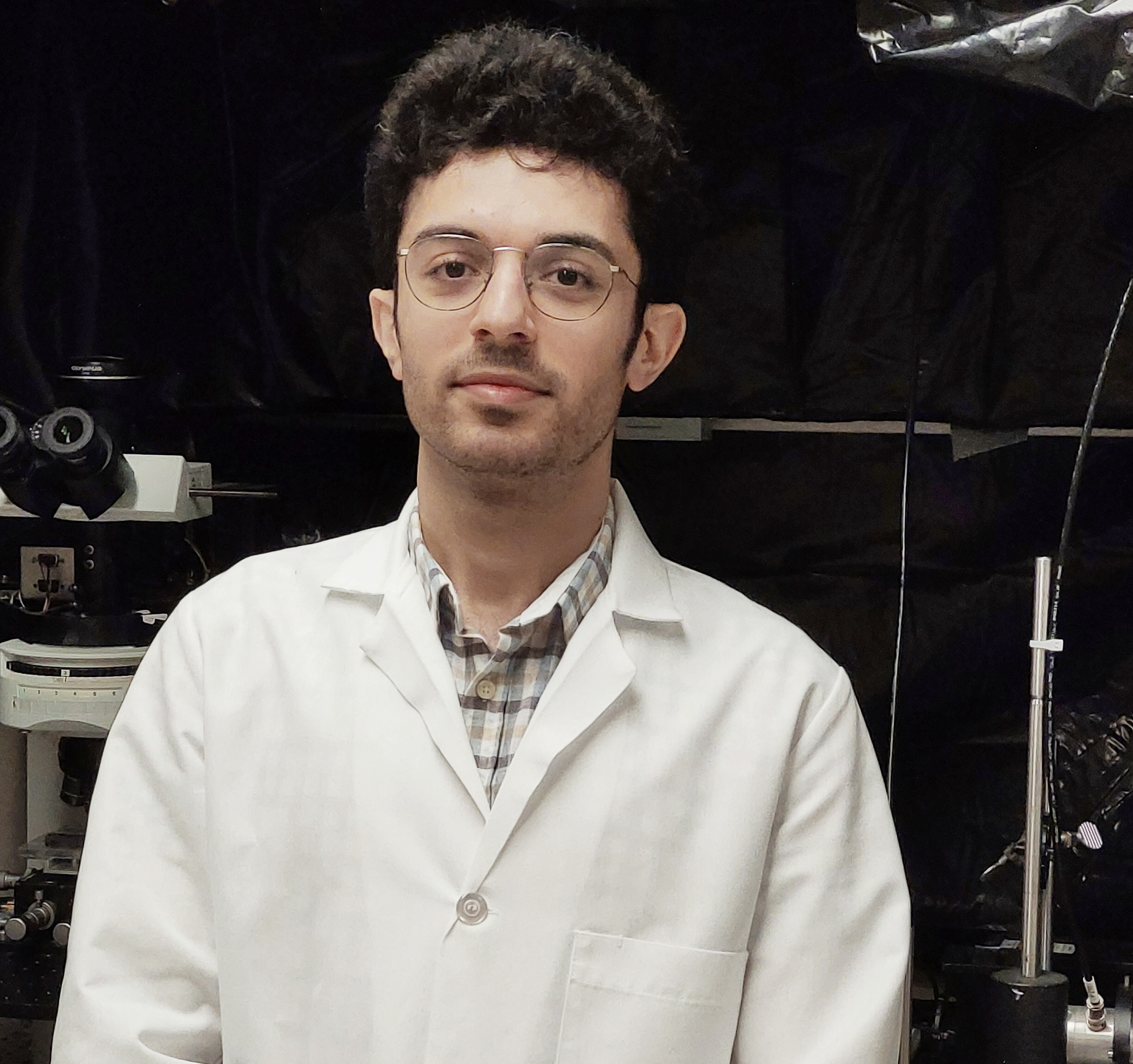 A photo of a student in a lab wearing a white lab coat