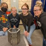 Students pose with a metal basket