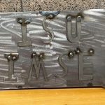 A metal cut out of Iowa with the text ISU IMSE