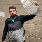 A student holds up his metal design, meant to resemble a professional wrestling belt