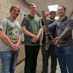 Students pose with their metal Eiffel Tower