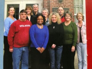 Photo of Sue with about 10 other staff members for a staff photo