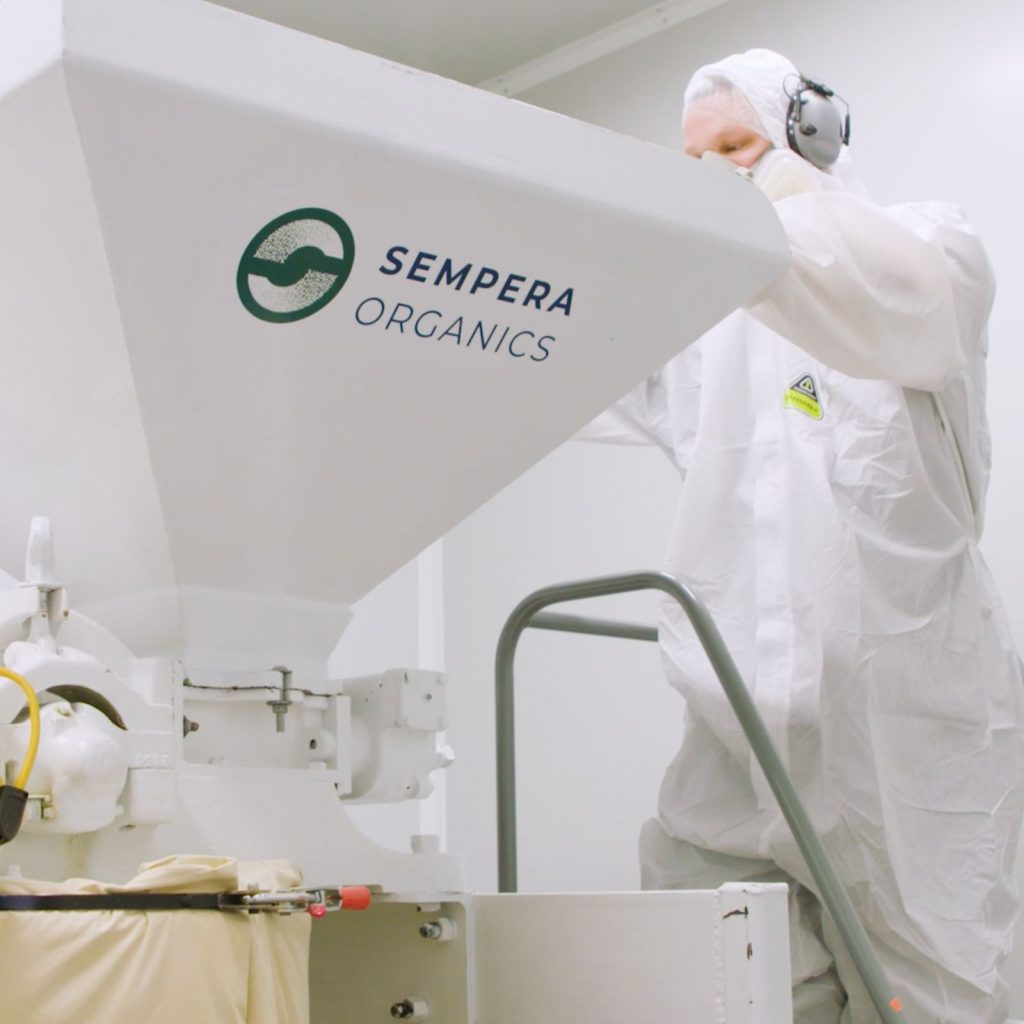 A person uses a piece of machinery inside the Sempera Organics lab.