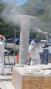ISU researchers spraying UHPC onto a cylinder structure
