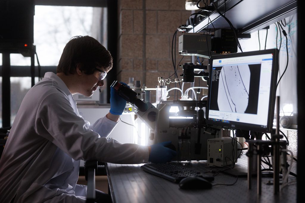 A student uses a microscope inside a lab