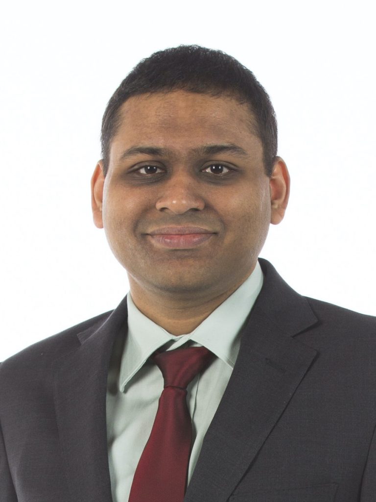 A headshot of a professor wearing a suit and tie