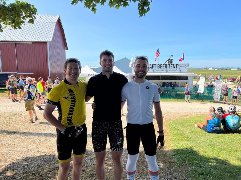 Three men smile and pose for the camera