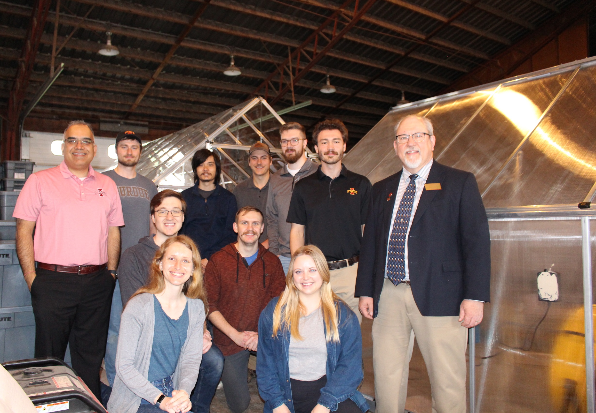 A group of student and instructors smile and pose for the camera