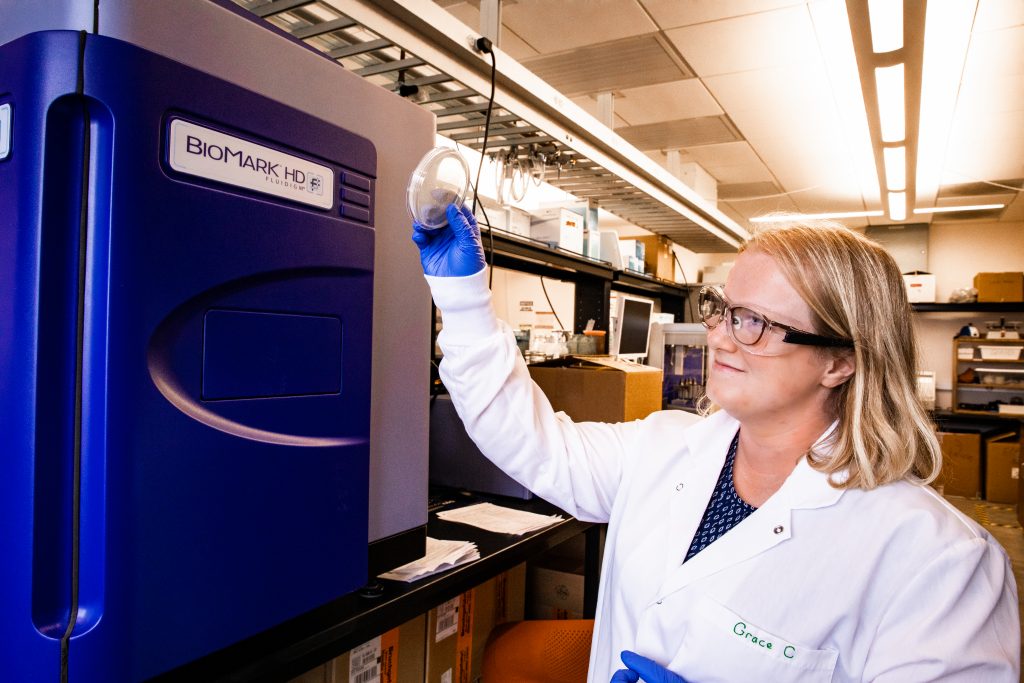 Photo of student Grace Carey holding and observing a Petri dish