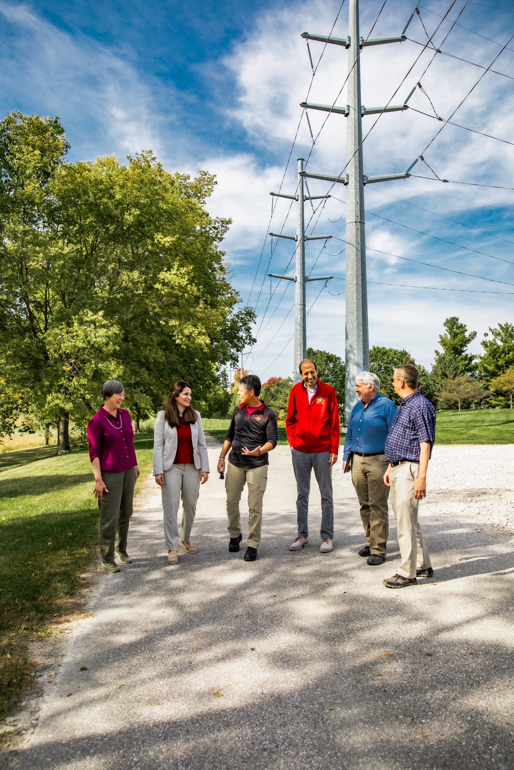 the team walking on a sidewalk with power lines and electrical infrastructure in the background