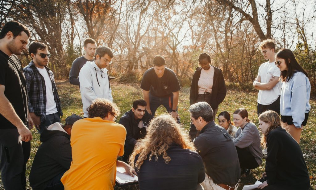 Photo of students huddled around a geotechnical engineering soil testing device