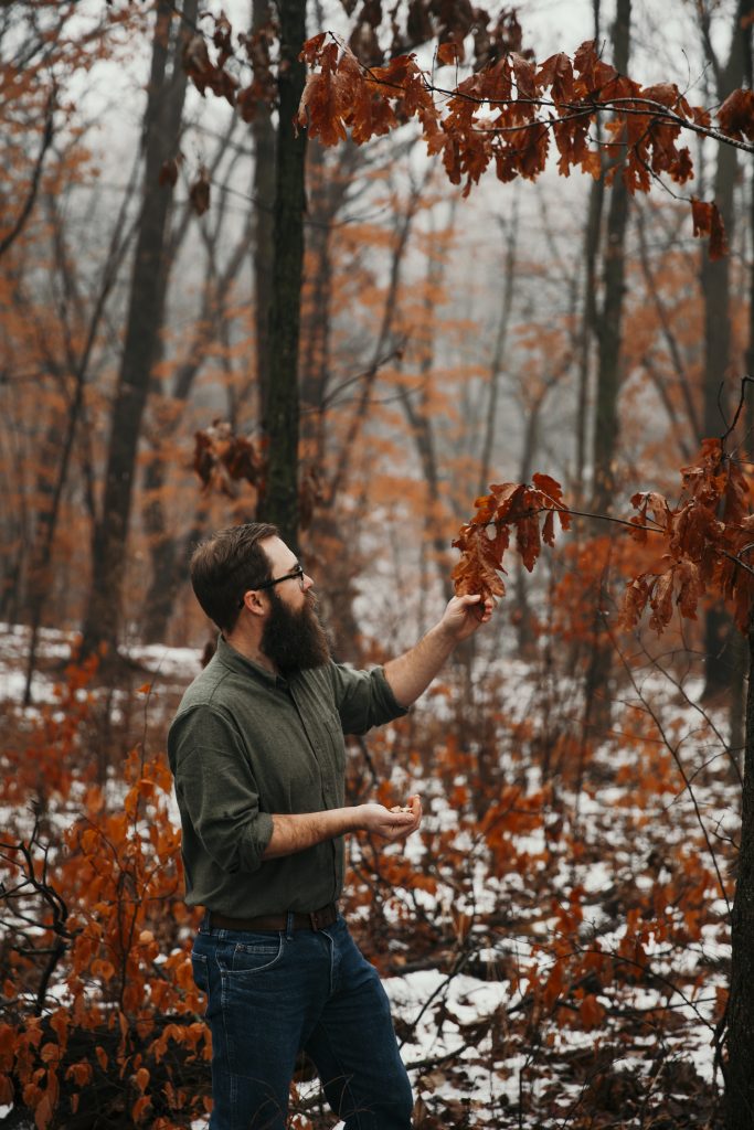 Billy Beck looking at leaves on a tree