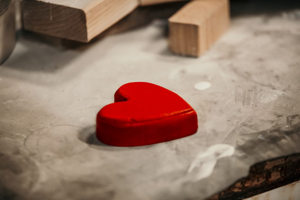 photo of single red heart on a concrete pad