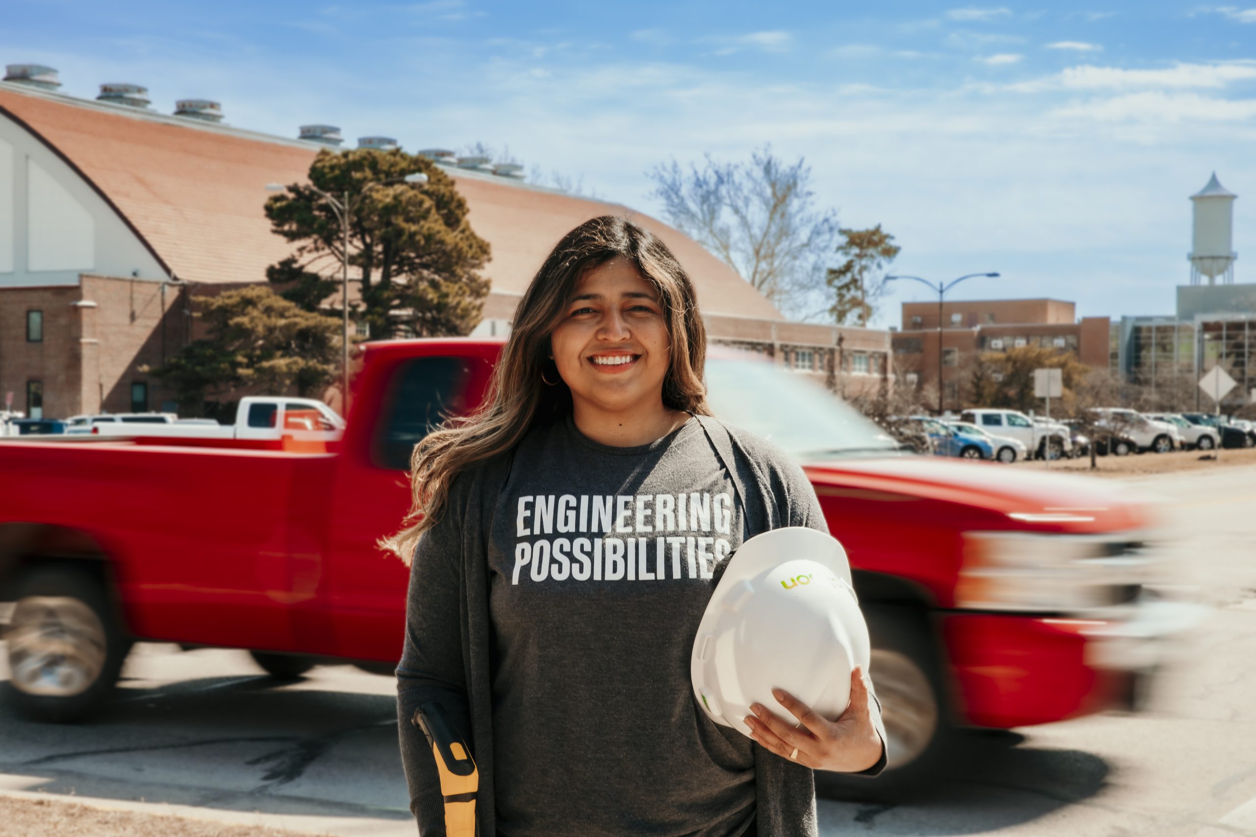 Sosa holding hard hat with car passing in the background