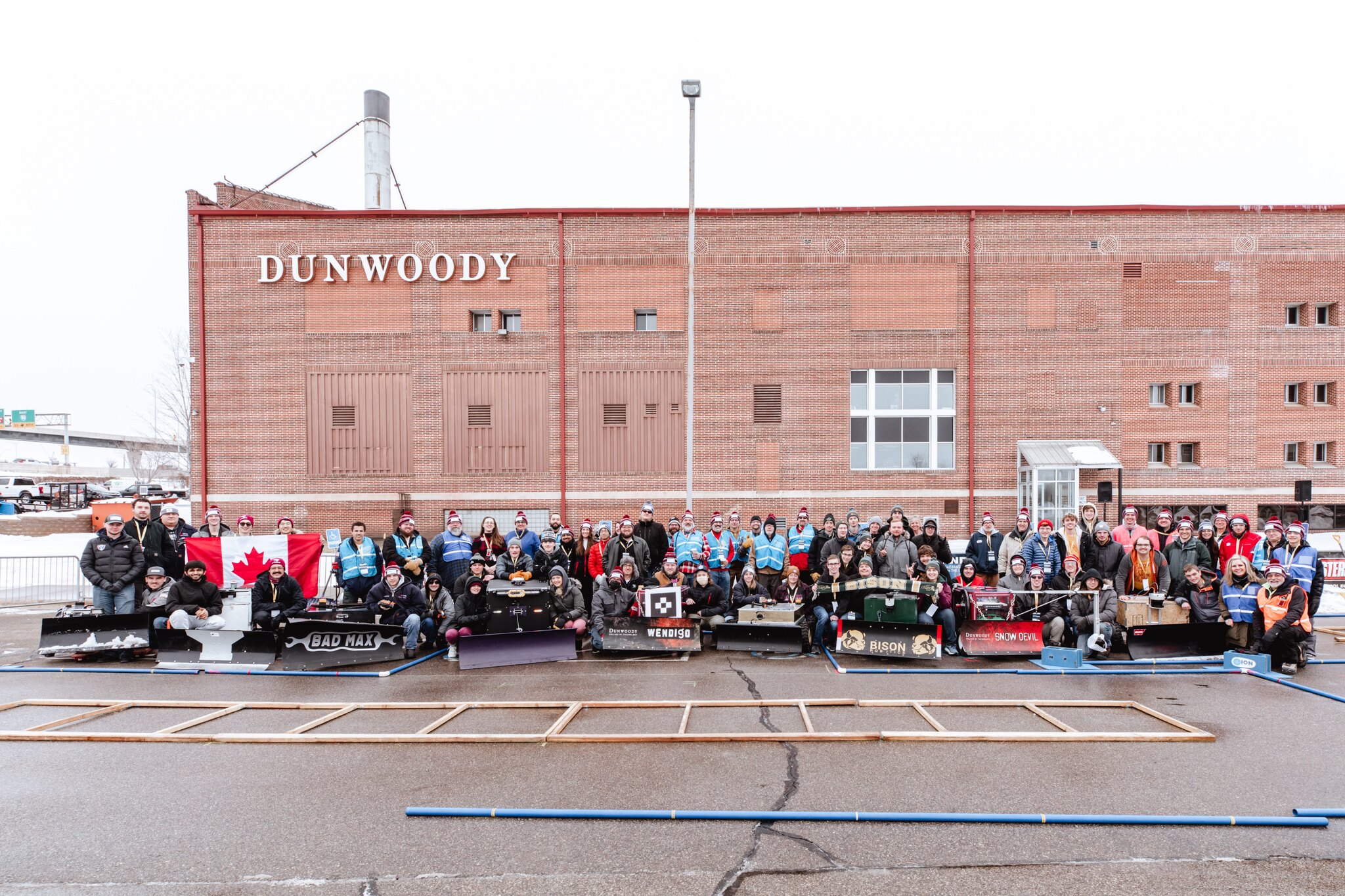 Snowplow contestants pose together in a group shot outside the Dunwoods college building.