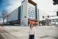 Herrera standing in front of the Hilton Des Moines Downtown Hotel