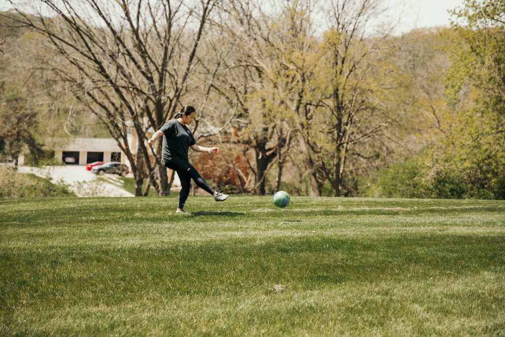 Jia Liu kicking soccer ball across the field
