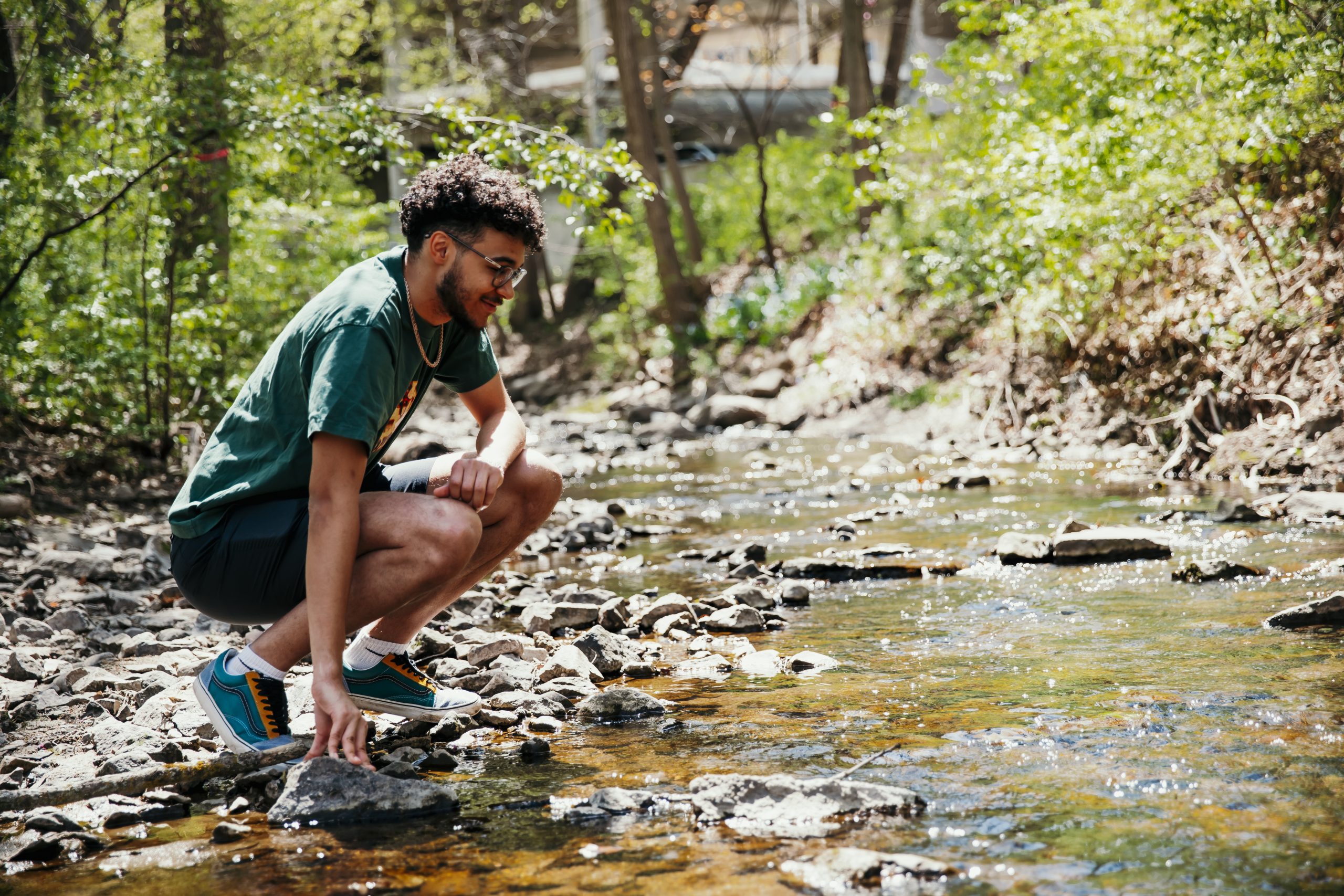 Nikolai Stevens standing by the creek looking down at the water