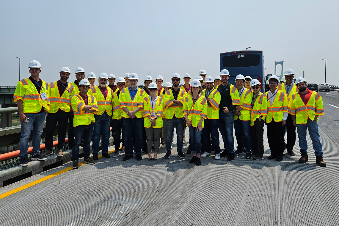 A group of people stands on a bridge deck