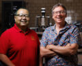 Jun Cui and Duane Johnson standing together and smiling in a lab setting.