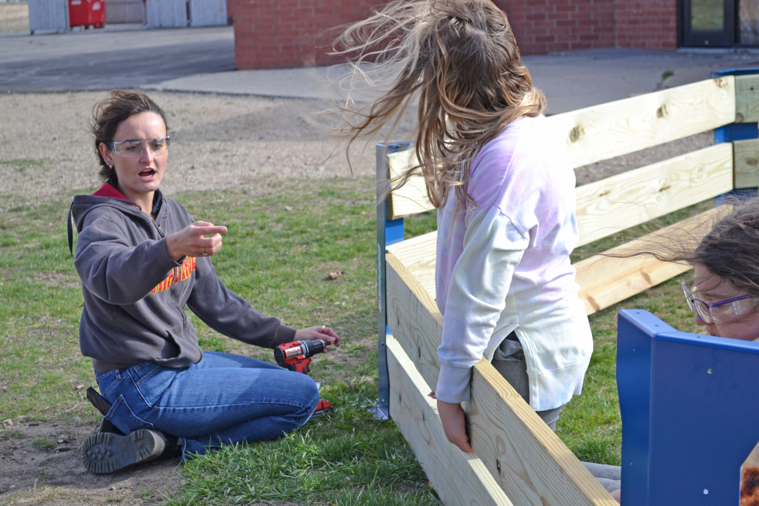 Abby McCormick giving instructions during assembly of gaga ball pit.