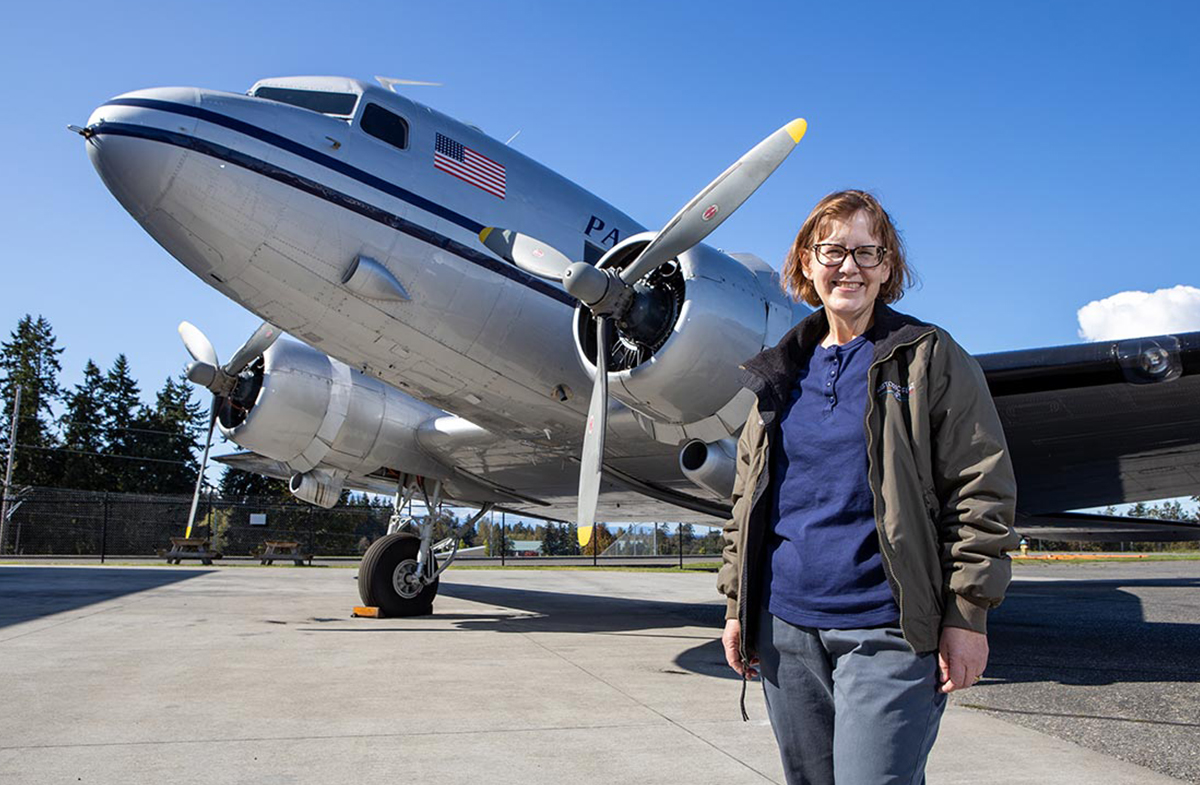 Vera Martinovich standing beside Douglas DC-3