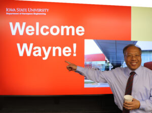 New Aerospace Engineering department chair Wayne Chen in front of slide stating "Welcome, Wayne" at department reception