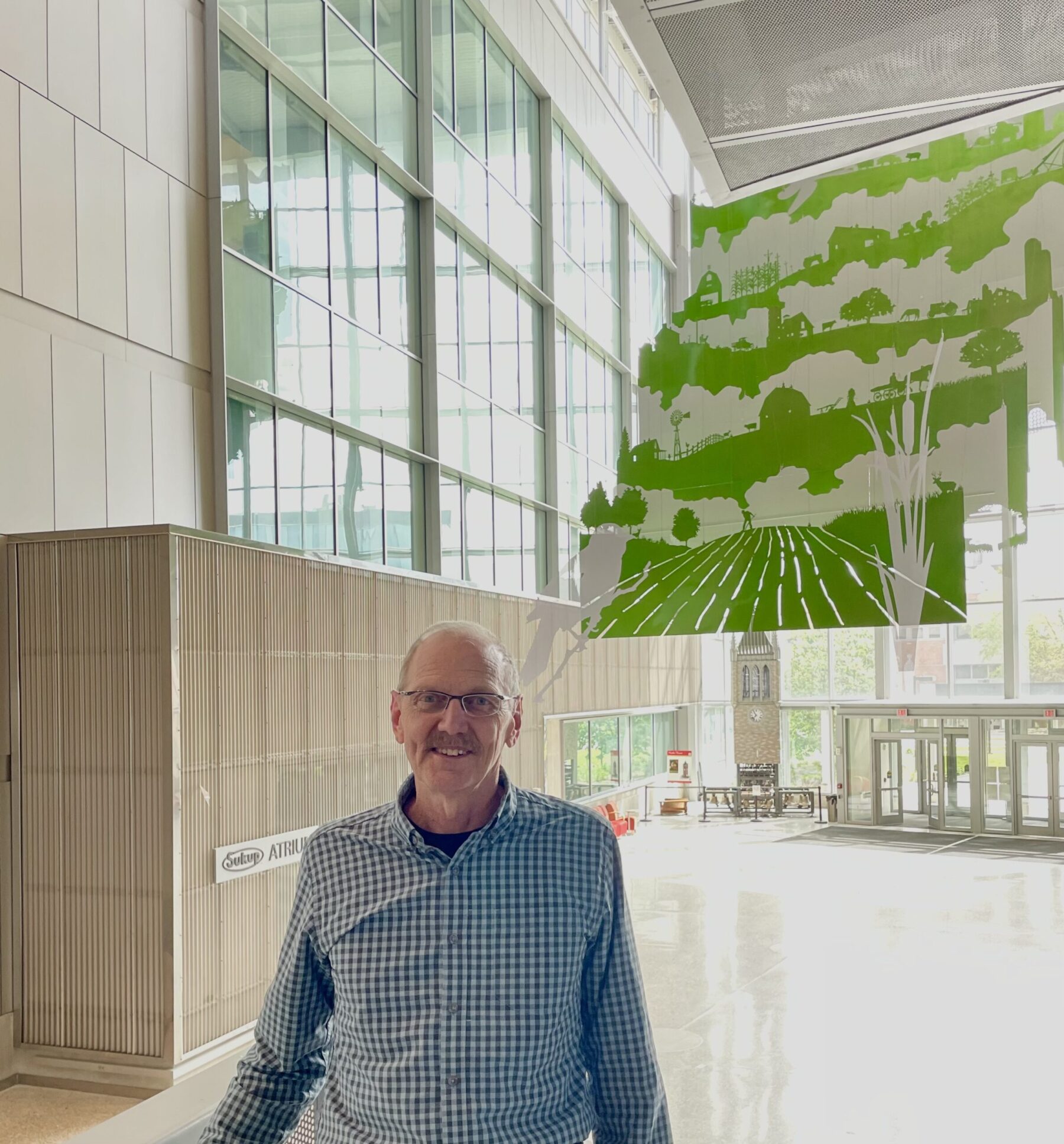 Professor of practice, Michael Anderson in front of the Sukup Atrium ceiling art.