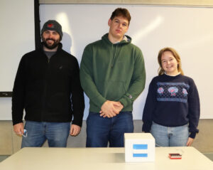 A student team poses with the portable oven they created for the course