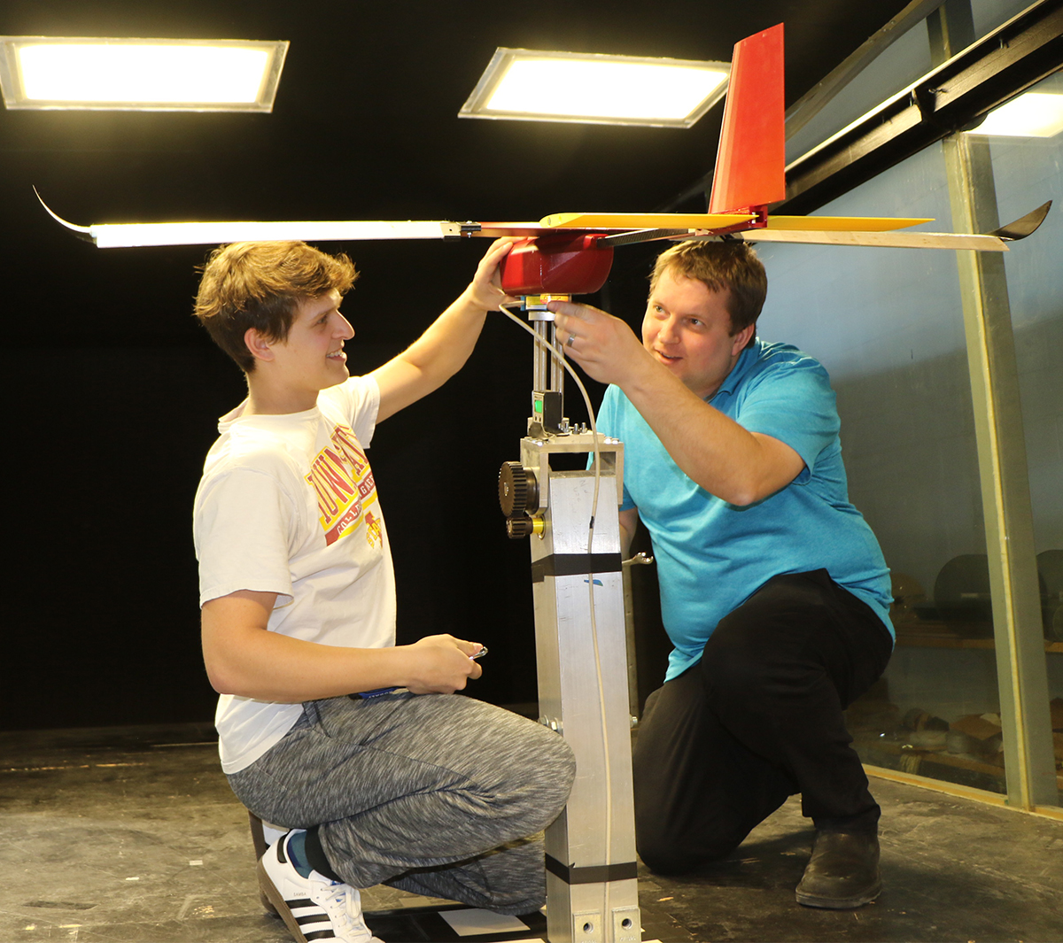 Student and course instructor in wind tunnel setting up a team plane for a test