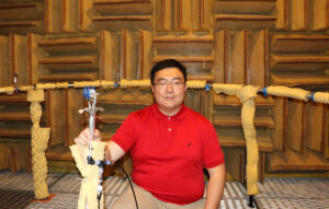 Zhangming Zhen in the anechoic chamber with equipment used for his ultrasonic whistles research.