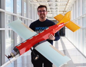 Spring semester team lead Justin Pope holding team's aircraft