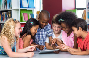 Children gathered at table with tablet