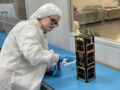 M:2:I team member checking CySAT-1 Cube Sat in laboratory