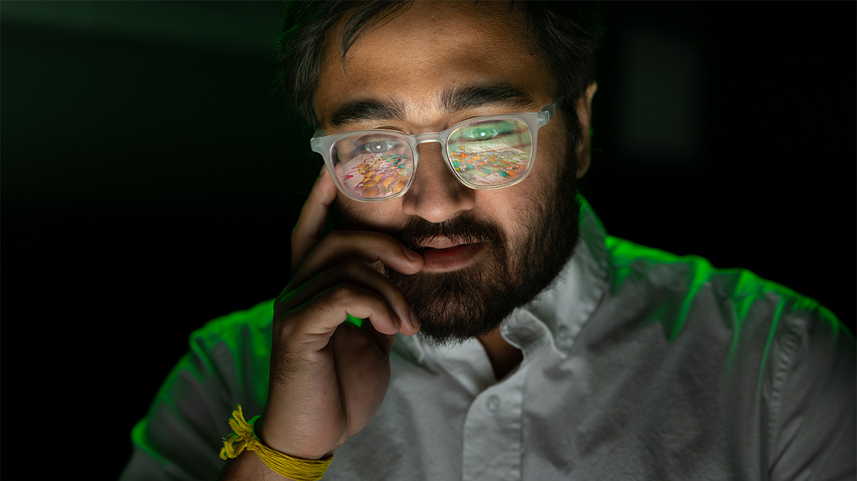 Ratul Chowdhury portrait photo with reflection of research images in glasses