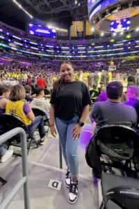 Macie McNurden standing courtside at a LA Lakers basketball game.