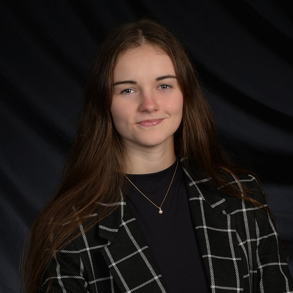 Morgan Ambourn in portrait shot with dark background.