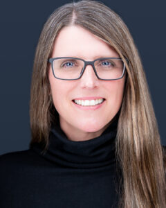 CCEE Alumni Hillary Isebrands Headshot. Long Brown hair with glasses in a black turtleneck.