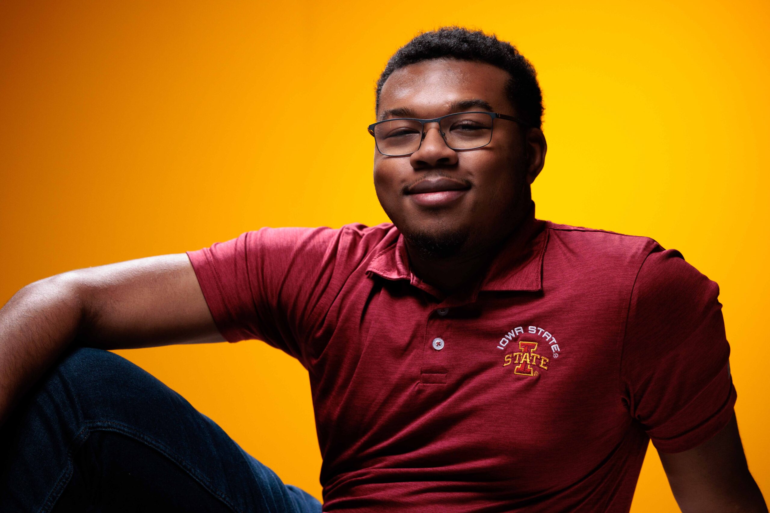 Greg Carter, outstanding senior in software engineering, poses for a photo in front of a gold background.