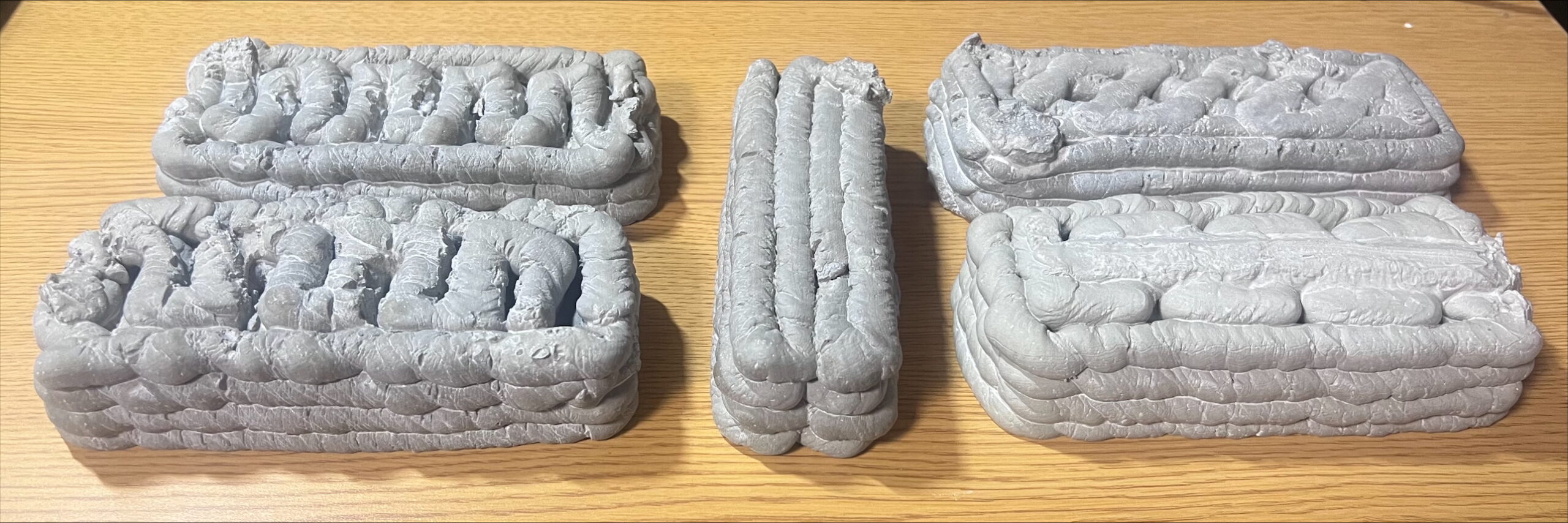 5 sample bricks of gray 3D printed concrete.