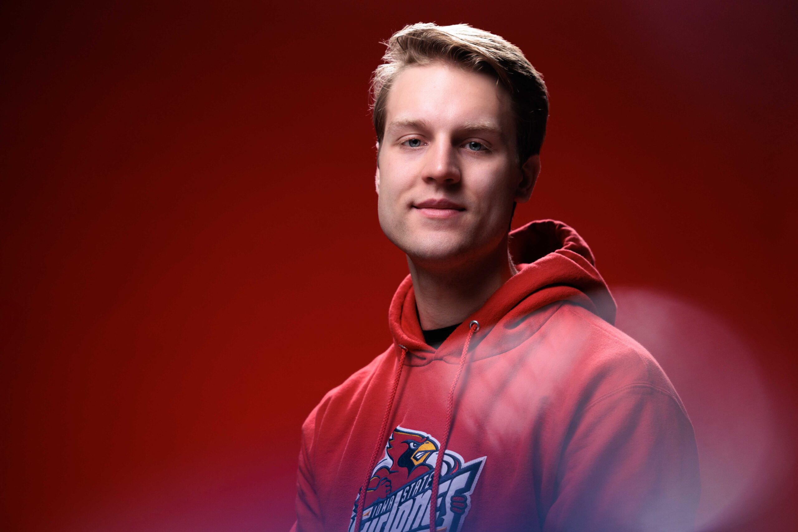 Michael Miller, outstanding senior in aerospace engineering, poses for a photo in front of a red background.