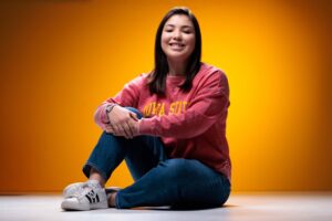 Sarah Mumm, outstanding senior in civil engineering, poses for a photo in front of a gold background.