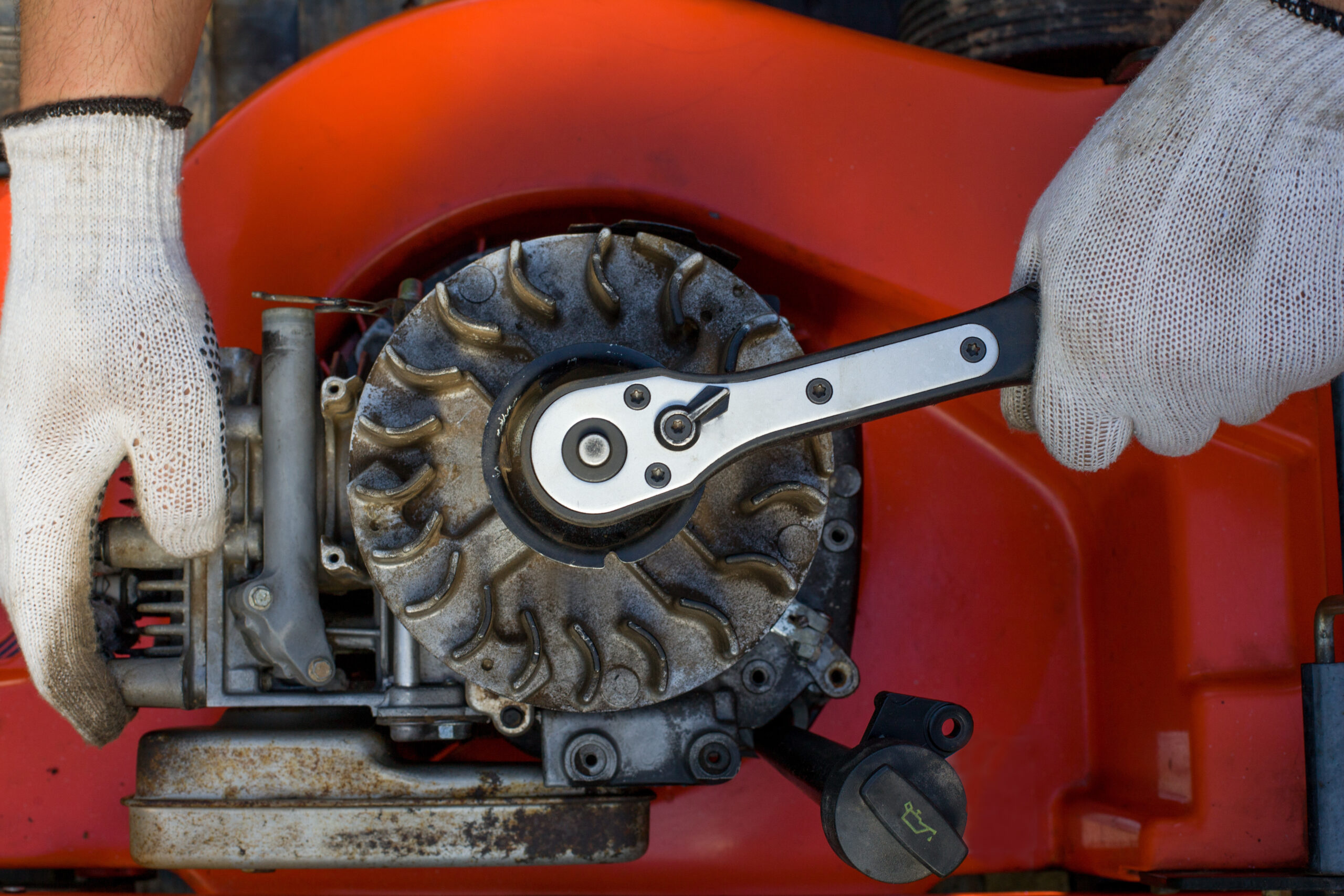 A closeup shot of fixing an old gas lawnmower