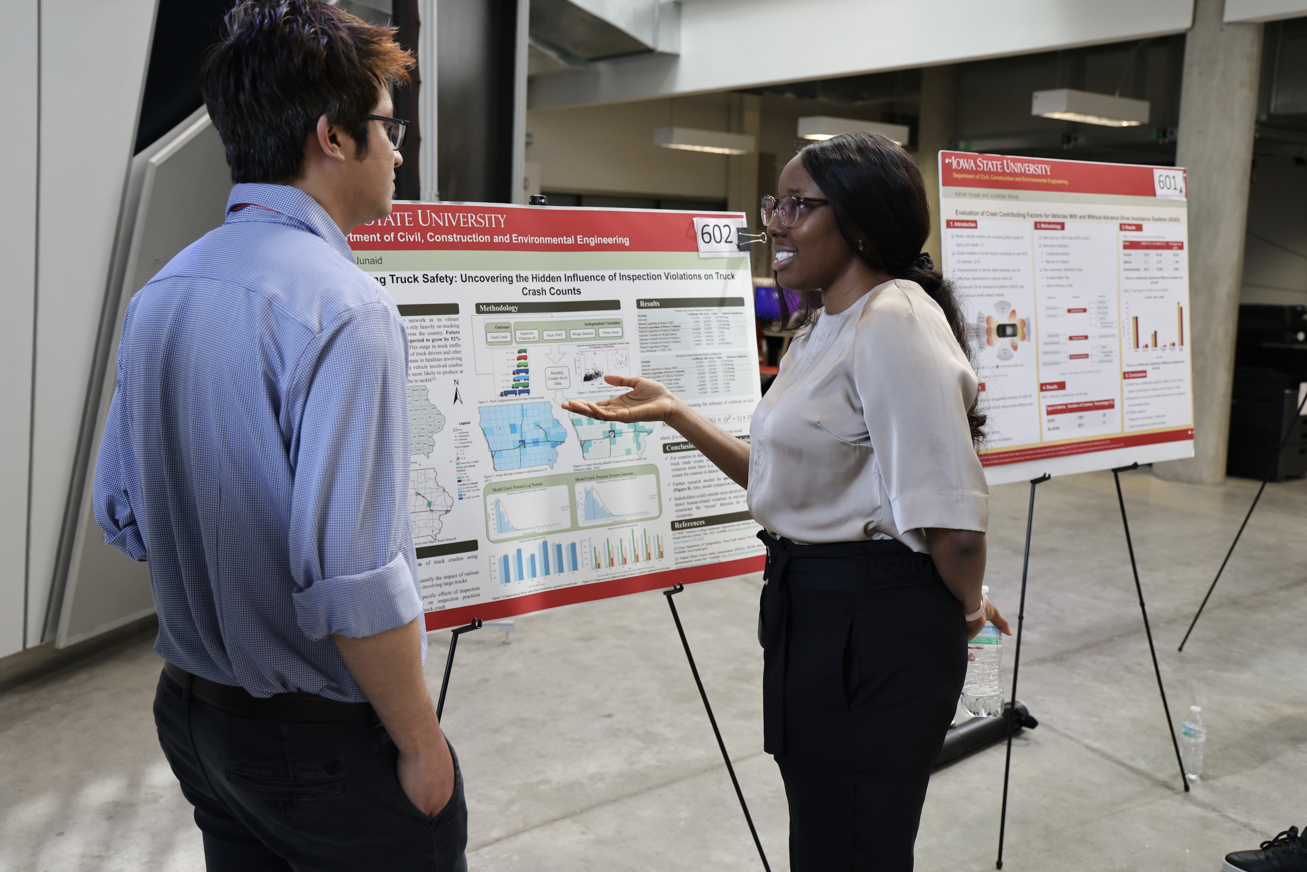 Student presenting her research poster to another student
