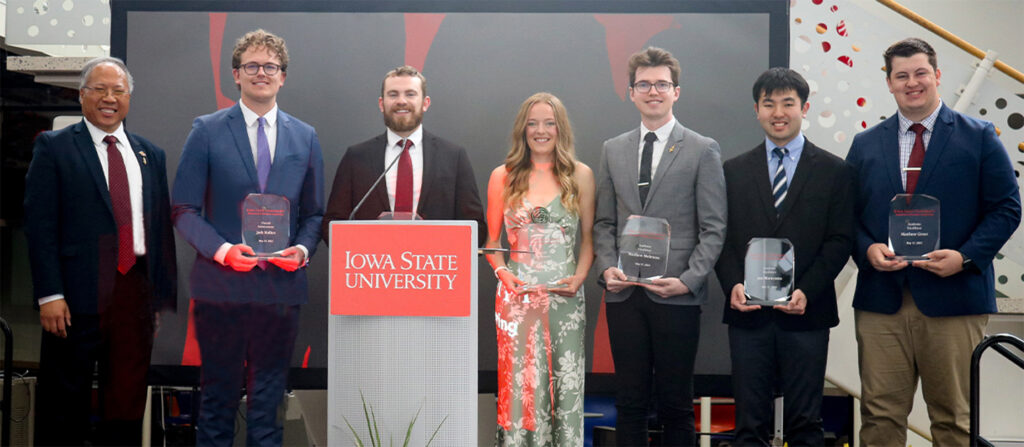 The six graduating seniors who received departmental awards are shown on stage at the pre-commencement reception holding their award plaques and posing with chair Wayne Chen.