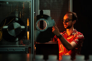 Alexander Goldman working in lab using furnace for metal alloy testing.