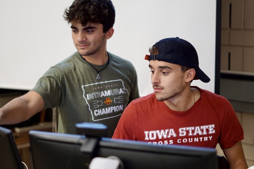Ernest Mattson and a peer look at computer screens.